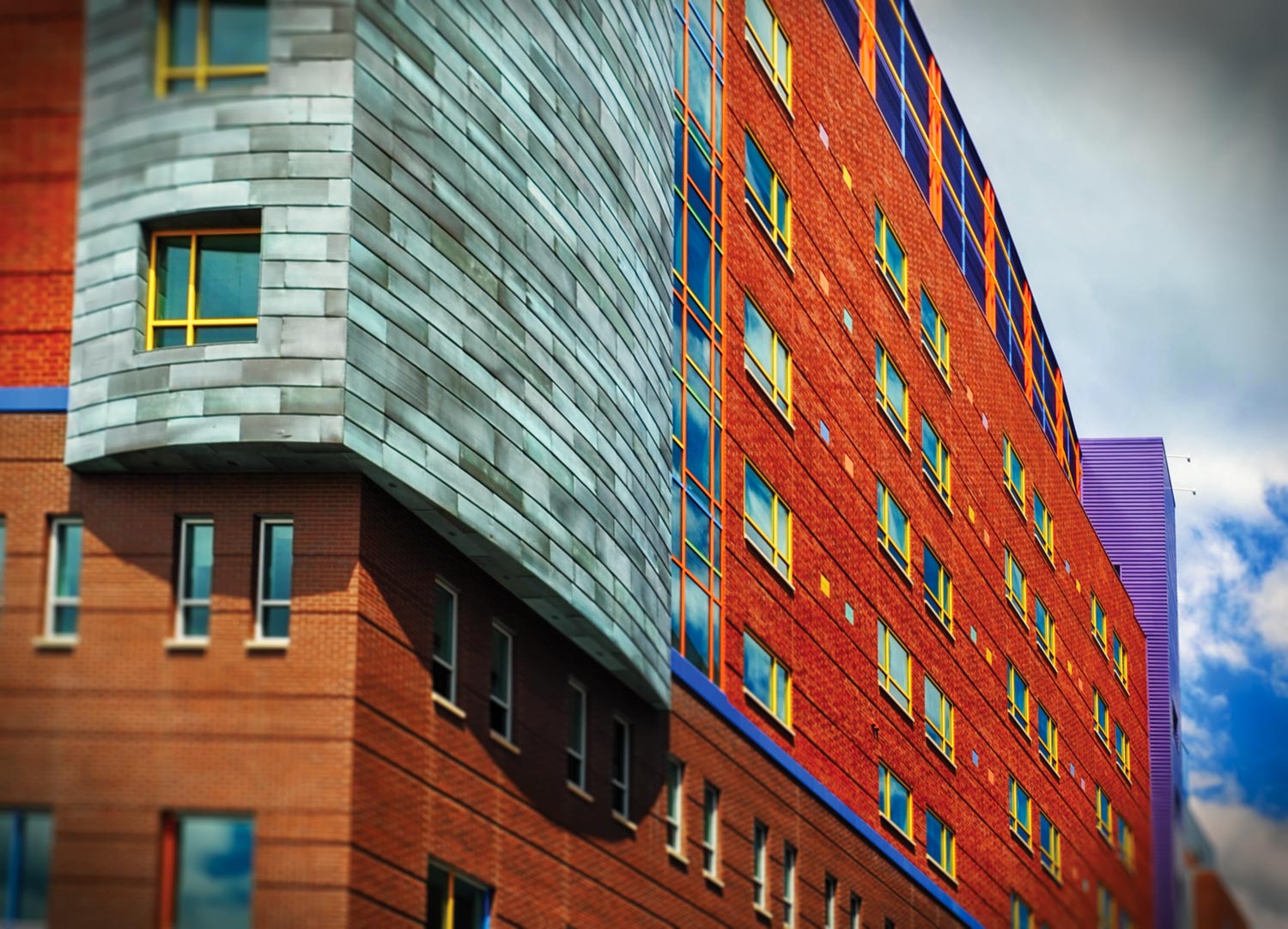 Side of building Children's Hospital metal patina panels installed plus accent gray louvers in photograph